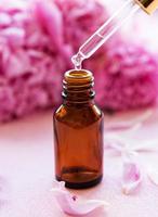 essentiële oliën voor aromatherapie en roze pioenrozen foto