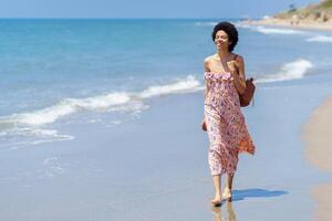 gelukkig etnisch vrouw Aan zanderig kust foto