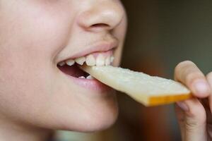gelukkig anoniem tiener- meisje aan het eten vers kaas plak foto
