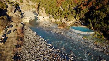 antenne dar visie van mensen zwemmen en het baden in heet veren thermisch baden. kadiut brug, Benje, toestaan, albanië. oude steen brug. mooi natuurlijk wonderen. vakantie en vrije tijd tijd. foto