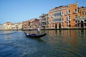 een Mens het rijden een gondel door de grachten van Venetië, Italië. toerisme in de stad van Venetië. UNESCO wereld erfenis. vervoer Aan de waterwegen van Venetië. foto