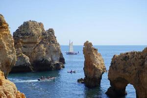 mensen Aan de boten genieten van een zomer dag Bij de magisch Ponta da piedade in de zuiden van Portugal, Algarve. beroemd plaats naar onderzoeken de grotten en tunnels in de oceaan. foto