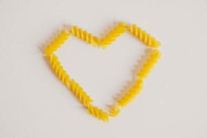 spiraalvormige pasta in de vorm van een hart op een witte achtergrond foto