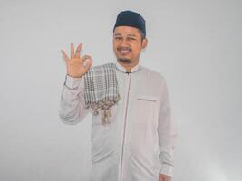 Moslim Aziatisch Mens glimlachen gelukkig en geven OK vinger teken Bij de camera foto