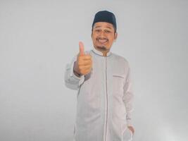 Moslim Aziatisch Mens glimlachen gelukkig en geven duim omhoog foto