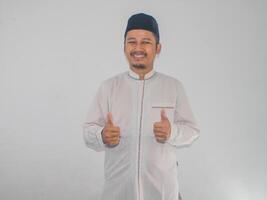 Moslim Aziatisch Mens glimlachen gelukkig en geven twee duim omhoog foto