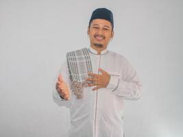 Moslim Aziatisch Mens glimlachen vriendelijk terwijl aanbieden een handdruk foto