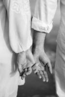 de bruid en bruidegom houden teder elkaars hand vast liefde