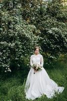 bruid met een bruidsboeket in het bos foto
