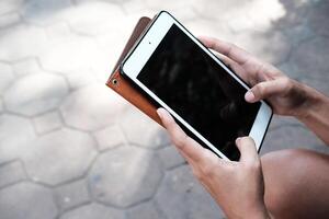 Gesloten omhoog Aziatisch vrouw hand- Holding tablet en tintje scherm voor online boodschappen doen met internet voor bedrijf reis. mensen ontspanning met sociaal media voor technologie Aan vakantie concept foto