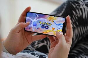 Pokemon Gaan mobiel iOS spel Aan iphone 15 smartphone scherm in vrouw handen gedurende mobiel gameplay foto