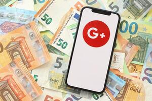 kiev, Oekraïne - april 1, 2024 google plus icoon Aan smartphone scherm Aan veel euro geld rekeningen foto