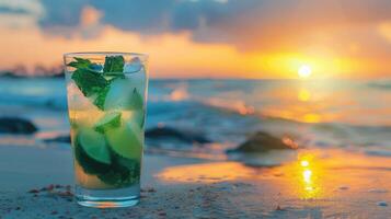 de bevroren glas van mojito drankjes Aan de strand Bij zonsondergang met vervagen achtergrond. foto