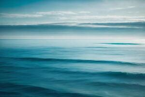 blauw oceaan golven en zon stralen in de oceaan foto