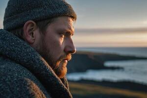 een Mens met een baard en hoed looks uit over- de oceaan foto