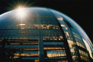 een groot glas gebouw met de zon schijnend door het foto