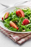 vers aardbei rucola salade met pijnboom noten geserveerd Aan een helder dag foto