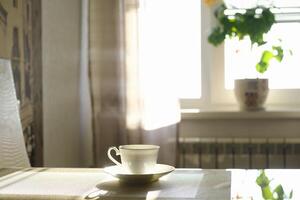 kop van heet stomen koffie Aan een zonnig ochtend- Aan de keuken tafel foto