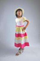 een Indonesisch weinig meisje vervelend modieus jurk met modellering houding. foto