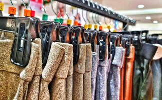 rijen van broek in een kleding op te slaan hangende netjes Aan hangers. foto