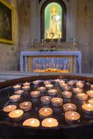 veel brandend kaarsen in kerk. selectief focus foto