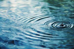 sereen water druppeltje rimpeling Aan blauw oppervlakte foto