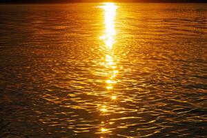 zonsondergang zonlicht pad Aan kalmte oceaan wateren foto