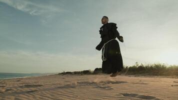 religieus monnik doet springen touw Aan de zacht zand strand foto