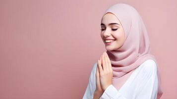 Europese vrouw vervelend sjaal is bidden en glimlachen Aan roze achtergrond foto