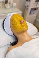 een meisje Bij een schoonheidsspecialist doet kunstmatig procedures. alginaat masker foto