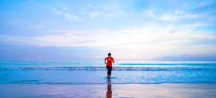 meisje met training joggen op het strand in de ochtend. ontspannen en blij zijn met hardlopen op zee. in de zomer foto