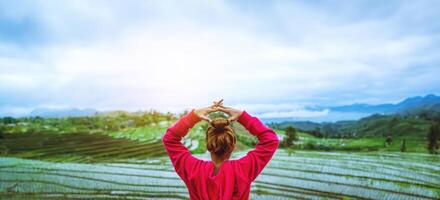 Aziatische vrouw ontspannen in de vakantie. spelen als yoga. op het balkon landschap natuurlijke field.papongpieng in thailand foto