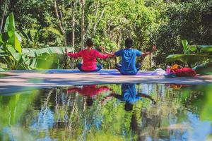 aziatische vrouw en aziatische man reizen natuur. reizen ontspannen. yogahoudingsconcept, goede gezondheidszorg met yogahoudingen. buiten oefening ontspannen yoga. foto