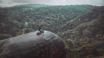 vrouwen reizen zitten op een klif op een rijke bosberg. Azië tropisch foto