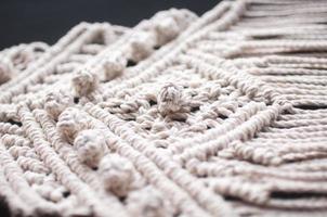 macramé ornament van witte natuurlijke katoenen draden op een zwarte achtergrond foto