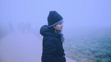 aziatische man ontspannen in de vakantie. graag reizen in de vakantie. tijdens de mistige winter foto