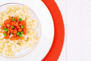 pastaboog met wortelblokjes, salami en doperwtjes foto