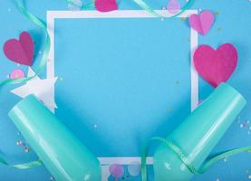 abstracte achtergrond met papieren harten, frame, blauwe champagneglazen voor Valentijnsdag. roze liefde en gevoel achtergrond voor poster, spandoek, post, kaart. bovenaanzicht foto