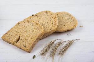 tarwegist rustiek brood met pompoenpitten op witte houten plank achtergrond foto