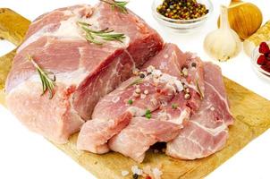 stuk rauw vers varkensvlees met kruiden voor het koken van vleesgerechten. studio foto