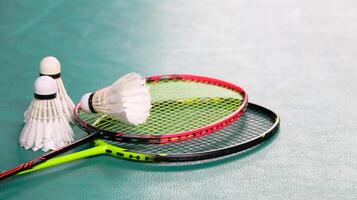 wit badminton shuttles en badminton rackets Aan groen verdieping binnen- badminton rechtbank zacht en selectief focus Aan shuttles en de rackets foto