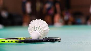 wit badminton shuttles en badminton rackets Aan groen verdieping binnen- badminton rechtbank zacht en selectief focus Aan shuttles en de rackets foto