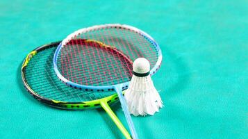 wit badminton shuttles en badminton rackets Aan groen verdieping binnen- badminton rechtbank zacht en selectief focus Aan shuttles en de rackets foto