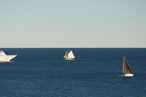 Monaco, wijnoogst zeil jacht en reusachtig reis voering zijn in zee Bij zonsondergang, reusachtig motor schip, rijkdom leven van miljardair foto