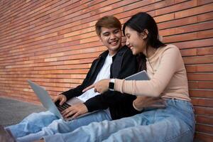 groep van jong interraciaal verschillend Universiteit studenten lezing leerboek en zittend buiten een klas onder een gebouw, innemend in een discussie samen, college campus, genieten van campus recreatie. foto