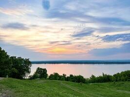 een sereen zonsondergang over- de volga rivier, met levendig lucht kleuren en weelderig rivieroevers in de voorhoede foto