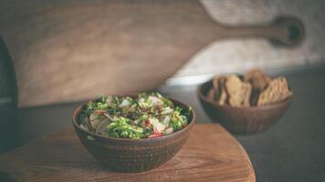 huis keuken. salade in een klei bruin bord. radijs, komkommers, sla. crackers. foto