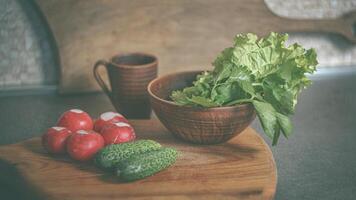 huis keuken. salade in een klei bord. radijs, komkommers, sla. poster 16-9 foto