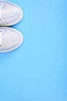 zilveren sneakers op een blauwe achtergrond met plaats voor tekst foto