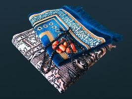 gevouwen moslim gebed mat gebruikt naar betalen met tasbih en khajoor Aan zwart achtergrond foto